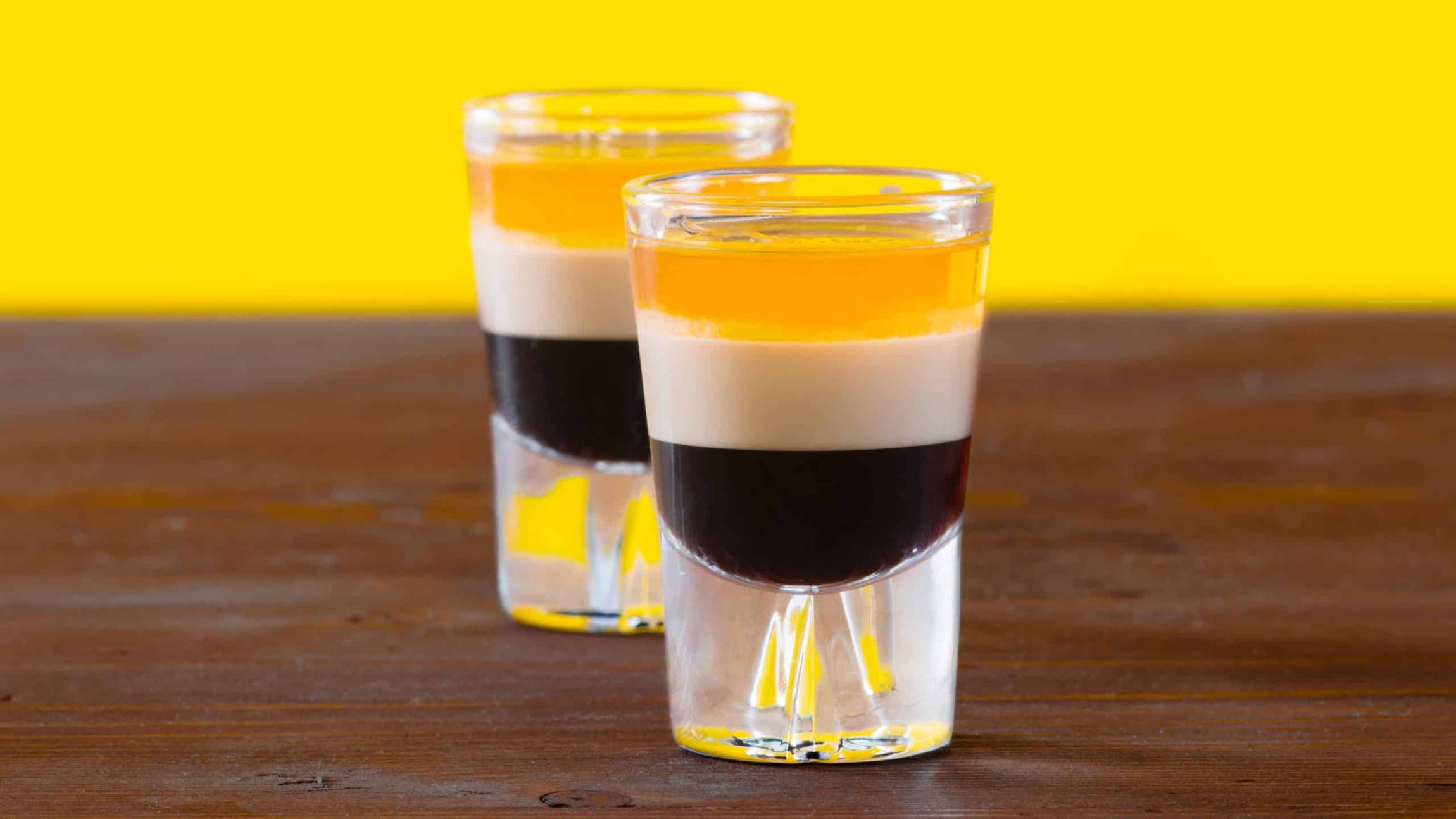 two B52 shots on a table with yellow background